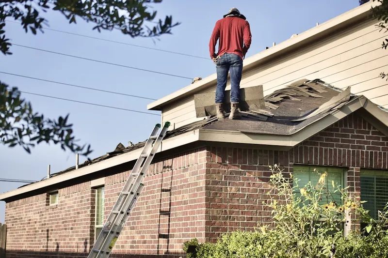 Professional roofer working on a residential roof in Hardage Farm